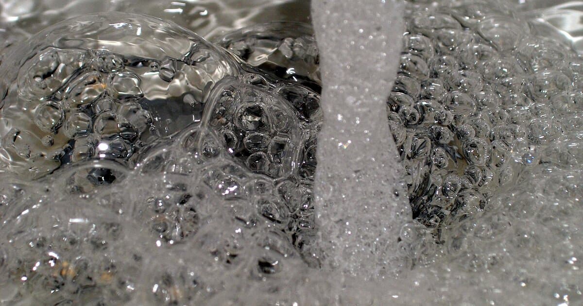 Close-up of a kitchen faucet aerator running water in a South Florida home